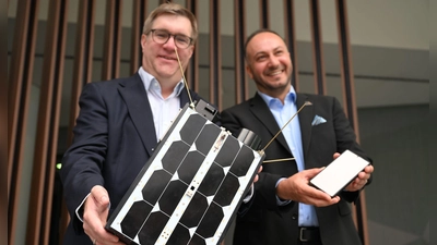 Demonstrativ gute Laune von O2-Manager Jörg Kablitz und OQ-Chef Omar Qaise, die bei der Vorstellung ihres Vorhabens ein Modell eines Satelliten dabeihatten.  (Foto: Wolf von Dewitz/dpa)