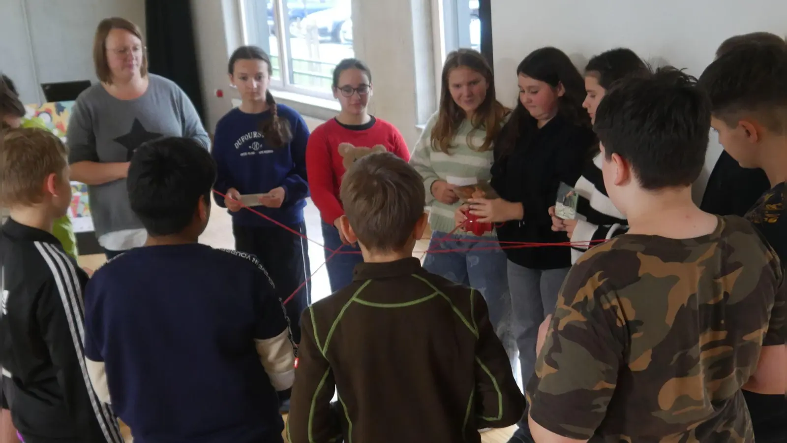 Die Sechstklässler der Mittelschule Scheinfeld beim Fadenspiel mit Lehrerin Julia Röder. (Foto: Martina Hinkelmann)
