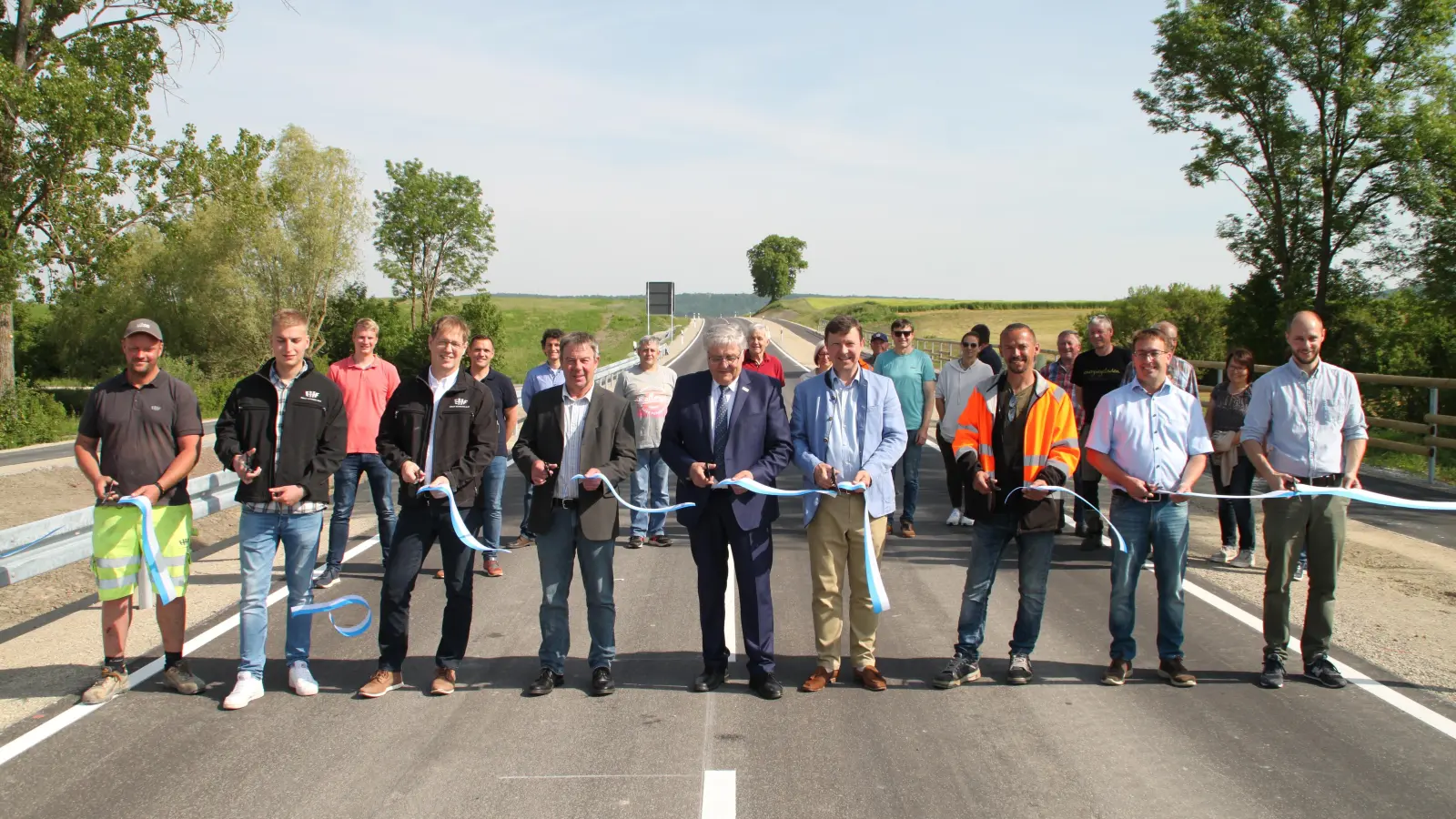 Andreas Kolb, Felix Röschenthaler, Ralf Puchinger (alle von der Baufirma), Heinrich Schmidt vom Staatlichen Bauamt, Landrat Helmut Weiß, Bürgermeister Jürgen Heckel, Christoph Arnold (Stadt Bad Windsheim), Roland Müller (Ortssprecher Berolzheim) und Frank Biedermann (Bauamt Ansbach) (von links) geben die Straße symbolisch für den Verkehr frei. (Foto: Hans-Bernd Glanz)