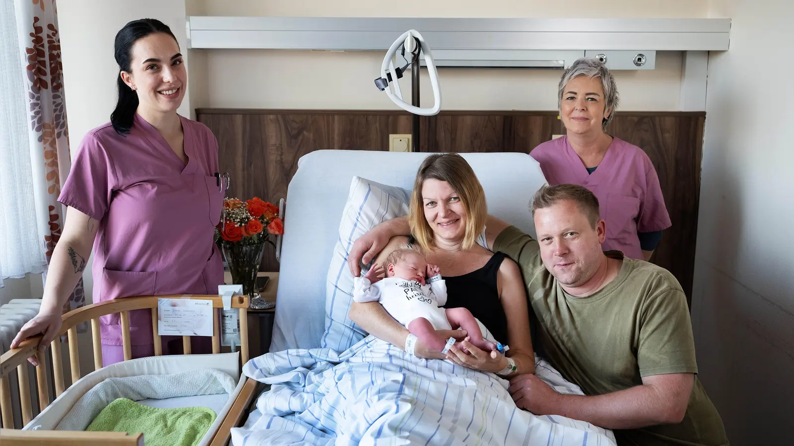 Ein stolzes Familien-Trio mit Mutter Nicole Weghorn, Vater Andreas Dorn und Jona. Die Hebammen Marisa Ehret (links) und Sabine Ixmeier (rechts) wurden zu Retterinnen in der Not und bastelten einen Ring. (Foto: ANregiomed/Tyler
 Larkin)