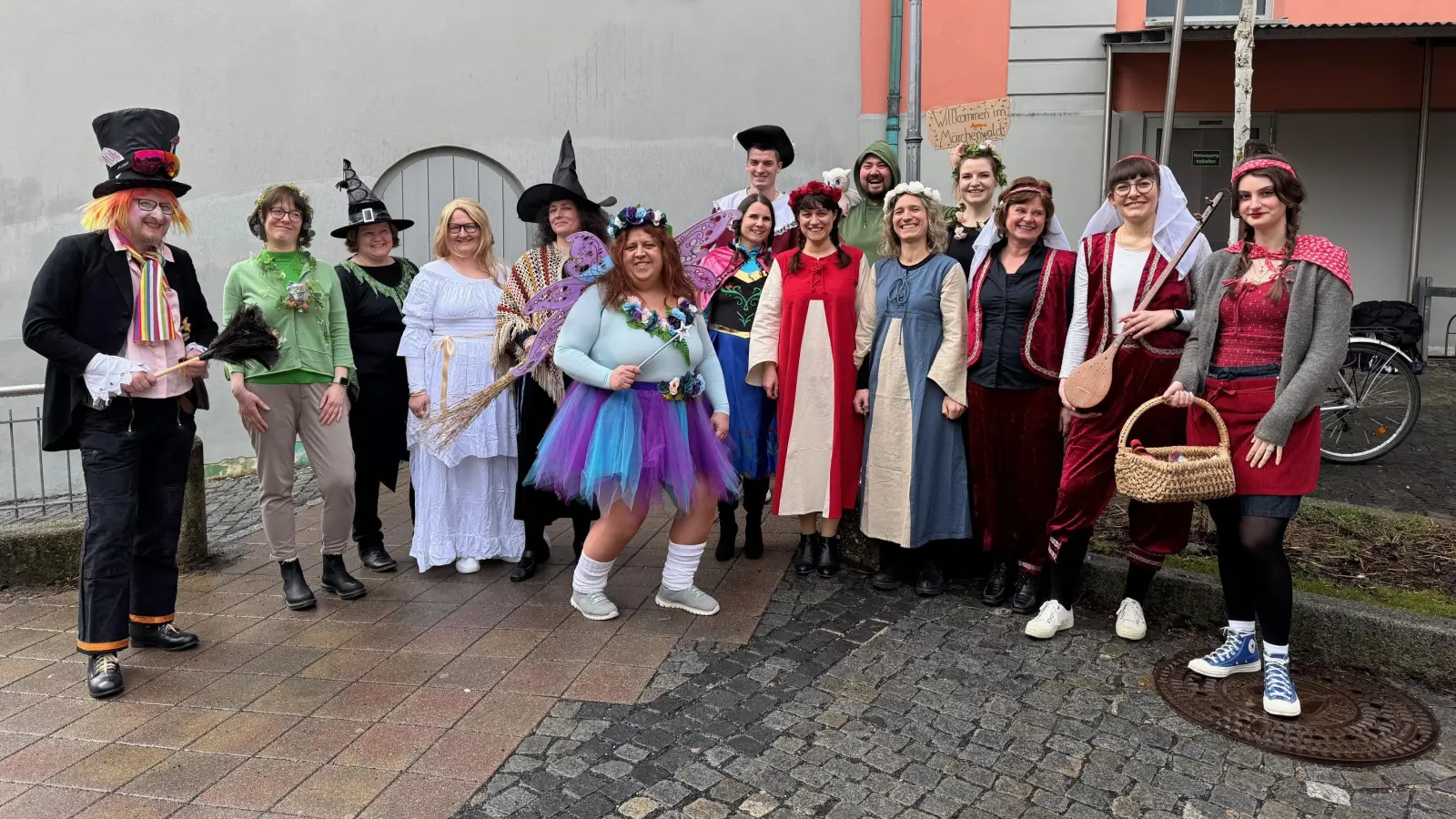 Lehrerinnen und Lehrer des Ansbacher Gymnasiums Carolinum, die am Freitag als Märchenfiguren in die Schule gekommen waren, posierten in einer Regenpause für ein Foto am Fuße des Turms. Nicht im Bild: der scheue Froschkönig und der böse Wolf. (Foto: Lara Hausleitner)