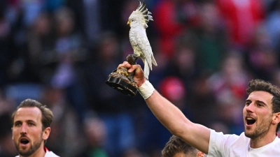 Leon Goretzka zeigt den Kakadu. (Foto: Tom Weller/dpa)