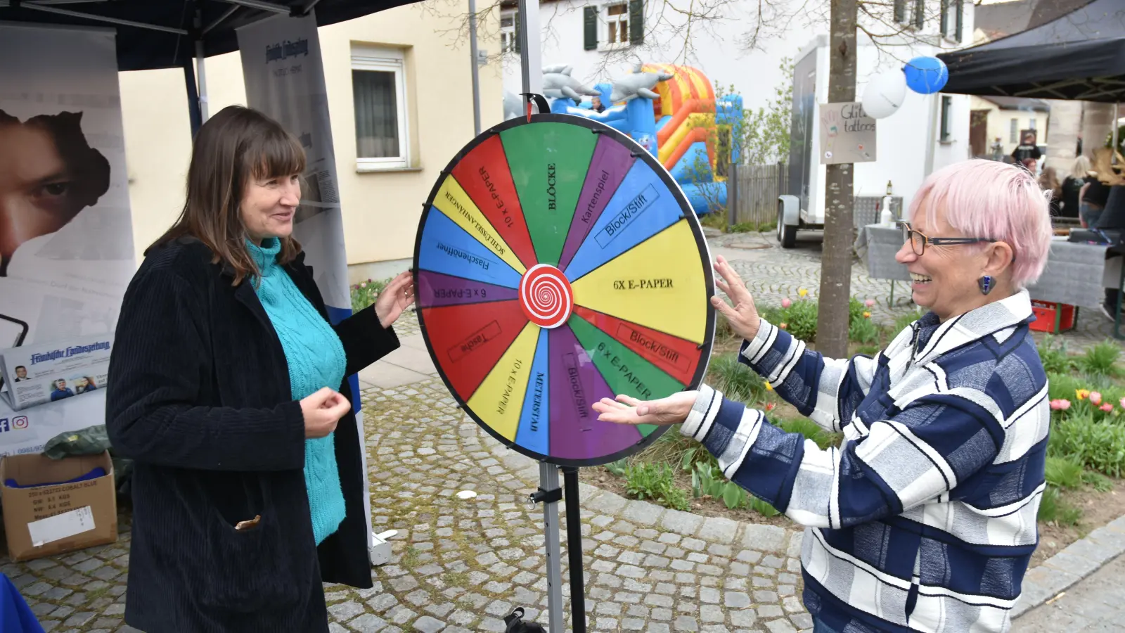 Beim Frühjahrsmarkt in Baudenbach präsentiert sich auch die Fränkische Landeszeitung. Am Stand mit dem Glücksrad sind Chefredakteurin Gudrun Bayer und Anita Dlugoß, Redakteurin in Neustadt (von rechts). (Foto: Stefan Neidl)