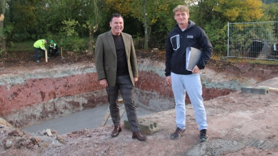 Bürgermeister Gerhard Rammler (links) und Bauleiter Manuel Bierschneider stehen vor der Grube für die Fundamente des neuen Funkmasts. (Foto: Stefan Neidl)