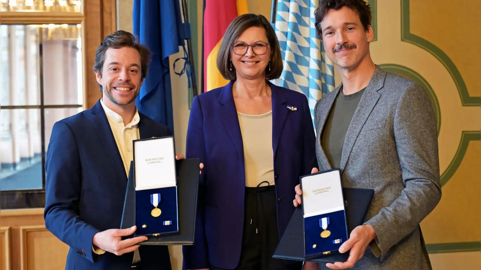 Landtagspräsidentin Ilse Aigner (CSU) zeichnet Tobias Krell und Florian David Fitz bei einem Nachholtermin mit dem Bayerischen Verfassungsorden aus. (Foto: Malin Wunderlich/dpa)