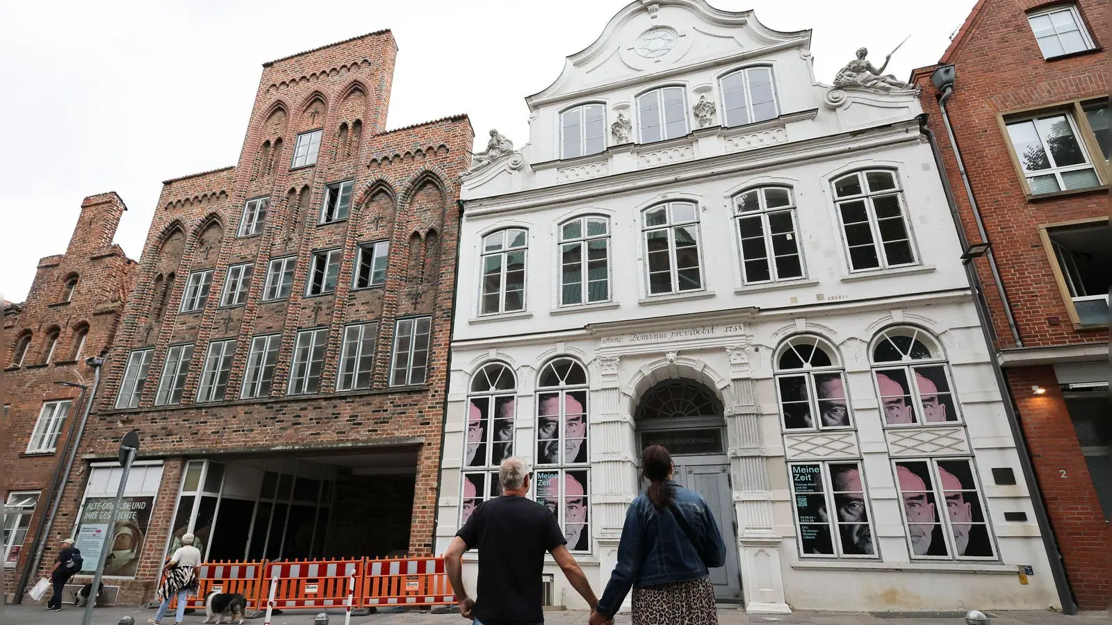 Passanten betrachten das geschlossene Buddenbrookhaus in der Lübecker Altstadt. (Foto: Christian Charisius/dpa)