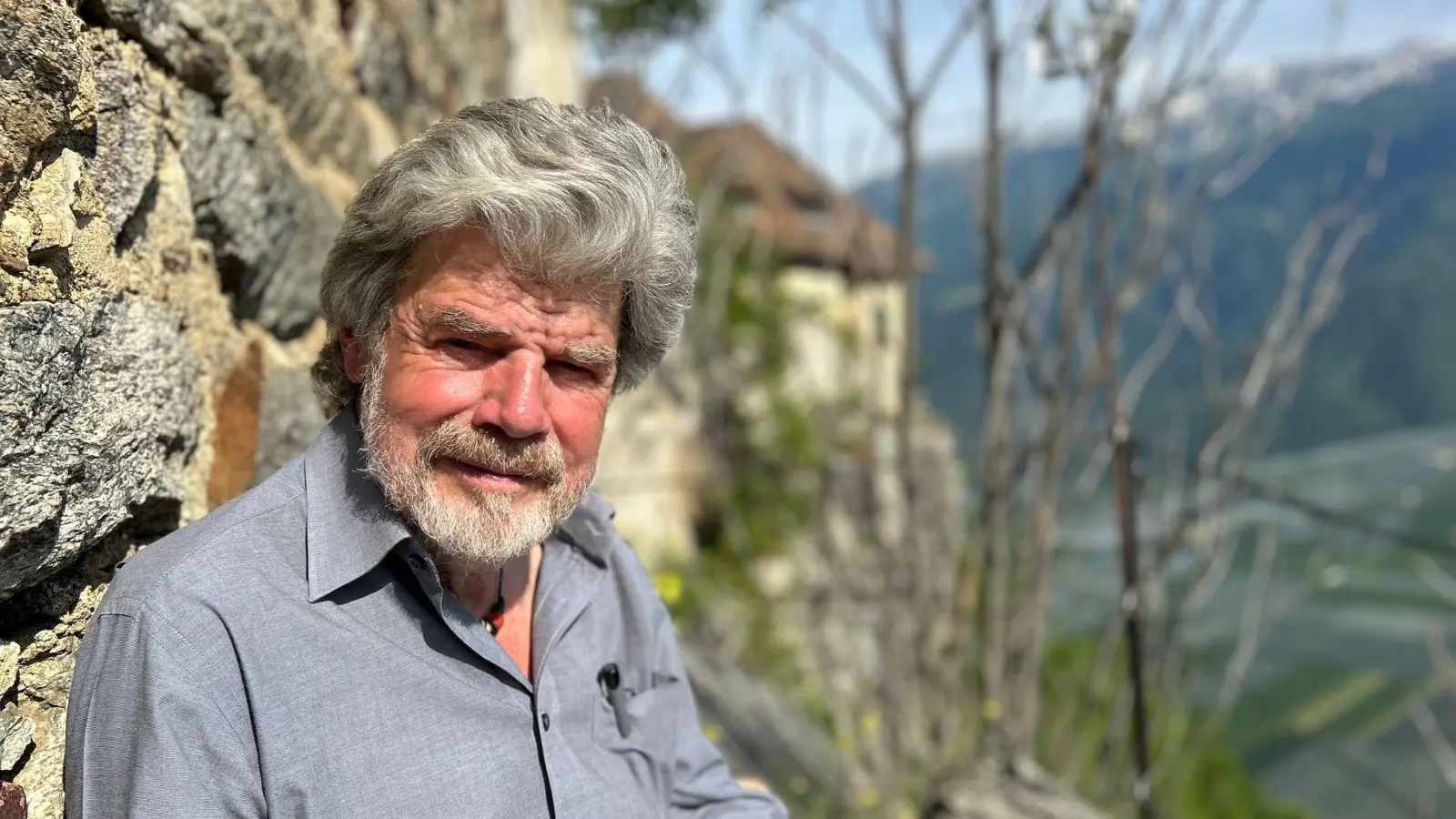 Der Bergsteiger Reinhold Messner sitzt an seinem Schloss Juval auf einer Bank. (Foto: Christoph Sator/dpa)