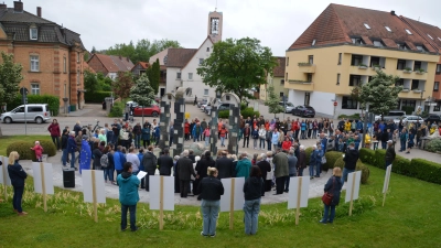 Zweimal um den Brunnen vor der Stadthalle herum und weiter zum Kriegerdenkmal bildete sich eine Menschenkette. Die Polizei schätzte die Teilnehmerzahl auf rund 200. (Foto: Johannes Zimmermann)