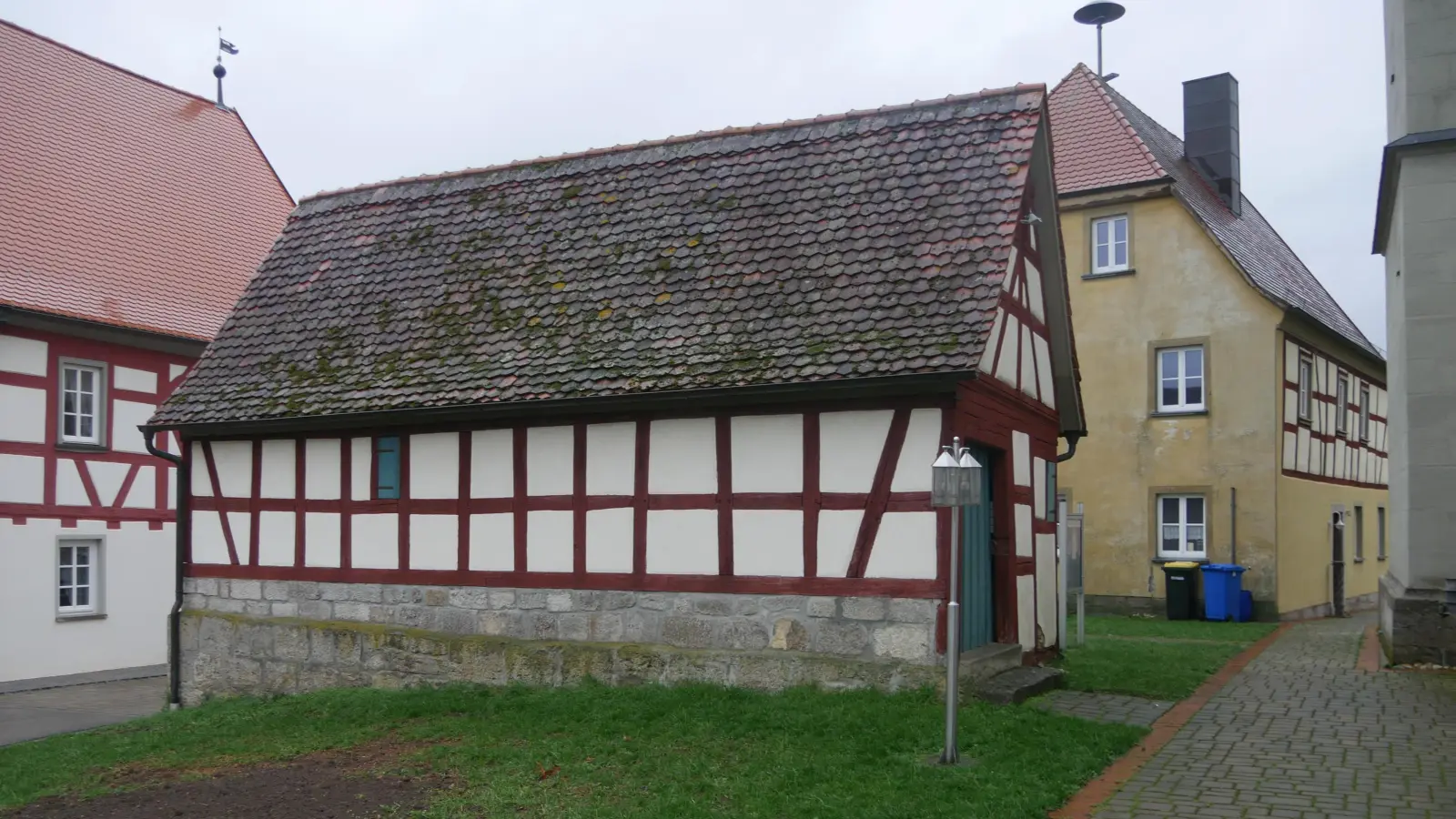 An die hintere Seite des alten Schulhauses (gelbe Fassade) soll ein Anbau erstellt werden. Das kleine Kellerhäuschen im Vordergrund wird dafür abgerissen. (Foto: Ulli Ganter)