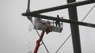 Arbeiter mit einem Hubsteiger entfernen Eis und Schnee von den Trägern des Stadiondachs in Hamburg. (Foto: Christian Charisius/dpa)