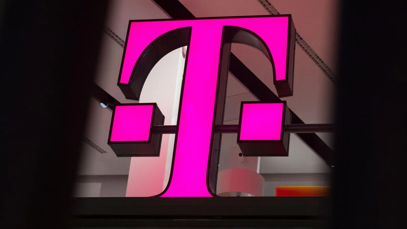 Ein Telekom-Logo strahlt in Magenta - für den Konzern sind die Behördenpläne eine gute Nachricht.  (Foto: Rainer Jensen/dpa/dpa-tmn)