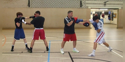 Der Vorsitzende und Cheftrainer des Boxclubs Feuchtwangen, Donato Braico (2. von rechts), bereitet seine Aktiven Omid Rezaie (rechts) sowie (von links) Zakiuallah Sadat und Mihai Irinel Lulea derzeit auf den Vergleichskampf im Mooswiesen-Weinzelt vor. (Foto: Jasmin Kiendl)