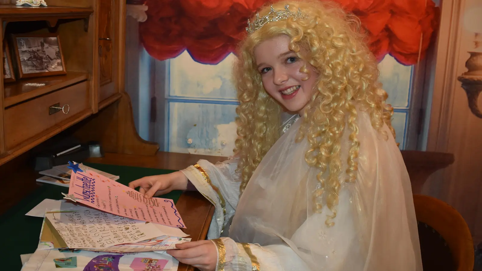 Das Christkind der Neustädter Werbegemeinschaft, Jule-Marie Wolf, und seine Helferinnen haben einiges zu tun, um die Briefe zu lesen und zu beantworten, die die Kinder nebst Wunschliste in den weißen Briefkasten am Rathaus einwerfen. Dies ist noch bis Ende der Woche möglich. (Foto: Ute Niephaus)