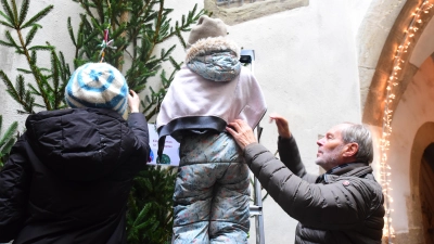 Claudia Weisbrod (links), eines der Vorschulkinder des Kindergartens St. Johannis und Zweiter Bürgermeister Dieter Kölle (rechts) beim Weihnachtsbaum-Schmücken. (Foto: Irmeli Pohl)
