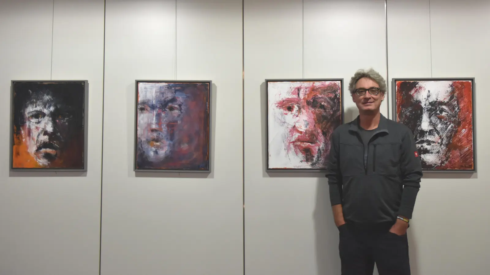 Dr. Peter Drechsel mit verschiedenen Gesichtern, Faces genannt. Seine Malerei konzentriert sich auf das Wesentliche. Schwarz und Rot sind die vorherrschenden Farben bei den Gemälden. (Foto: Anita Dlugoß)