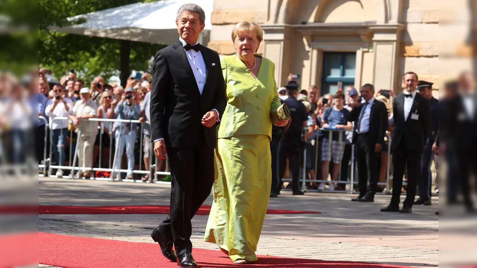 Angela Merkel mit Ehemann Joachim Sauer bei der Eröffnung der Bayreuther Richard-Wagner-Festspiele 2022: Wegen ihres leuchtend grünen Outfits wurde auch die ehemalige Bundeskanzlerin in den sozialen Medien zum „Brat Girl“ ernannt. (Foto: Karl-Josef Hildenbrand/dpa/dpa-tmn)