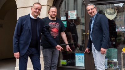 Auf das Zeichen der „Handy-Aktion“ im CVJM-Weltladen weisen Oberbürgermeister Thomas Deffner, Jan Schulte von dem Verein und Dekan Dr. Matthias Büttner hin (von links). (Foto: René Chlopotowski)