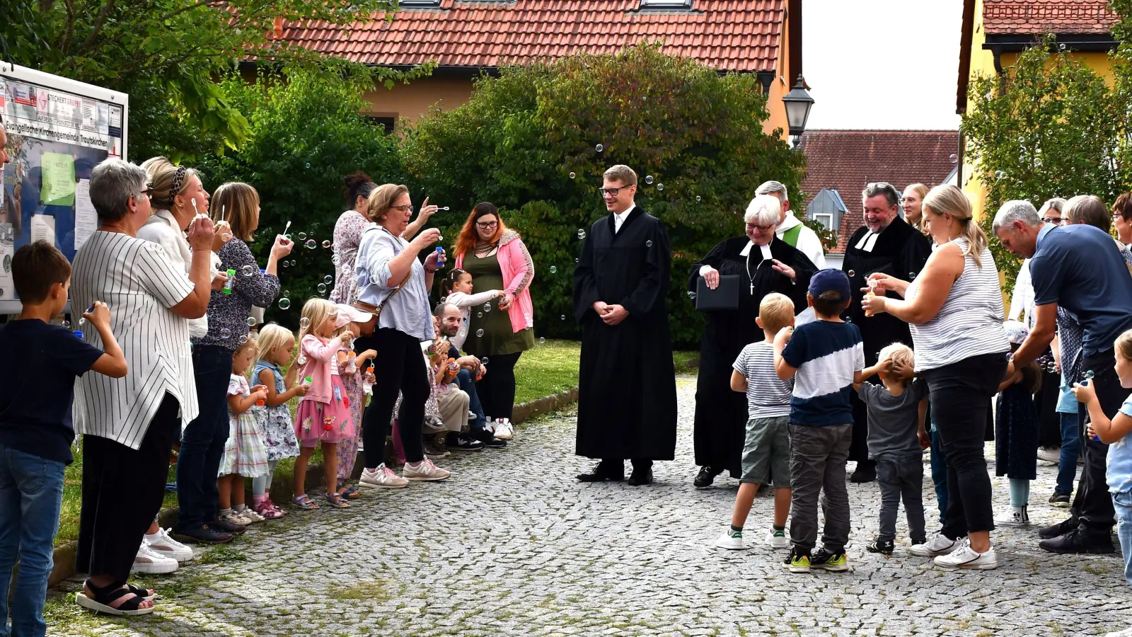 Religionspädagoge Philipp Fiedler (Mitte) ist ins Trautskirchener Pfarrhaus eingezogen. Er wurde unter anderem von den Kindergartenkindern des Ortes und zahlreichen weiteren Gemeindeangehörigen begrüßt. (Foto: Gudrun Schwarz)