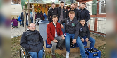 Fünf Kästen Bier brachte Bürgermeister Jürgen Heckel (rote Jacke) den Ickelheimer Ortsburschen als Auslöse für das Brunnenmodell mit. Das durften sie am Ende dann aber auch gleich noch behalten. (Foto: Katrin Merklein)