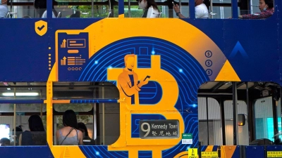 Eine Werbung für die Kryptowährung Bitcoin auf einer Hongkonger Straßenbahn. Kryptoanleger weltweit glauben laut einer Umfrage, dass es weiter aufwärts geht. (Foto: Illustration) (Foto: Kin Cheung/AP/dpa)