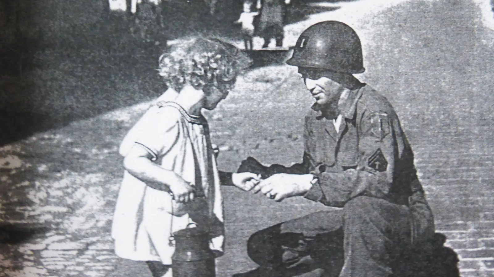 US-Sergeant Ralph Gordon gibt einem Mädchen einen Kaugummi, heißt es in einer Bildunterschrift zu diesem Foto. In dem Artikel aus dem „Life“-Magazin aus dem Jahr 1945 heißt es unter anderem, für Gordon seien alle örtlichen Zivilisten „Krauts“, und zwar „some of them good, some bad“, also einige davon seien gut, einige schlecht. (Foto: Life-Magazin)