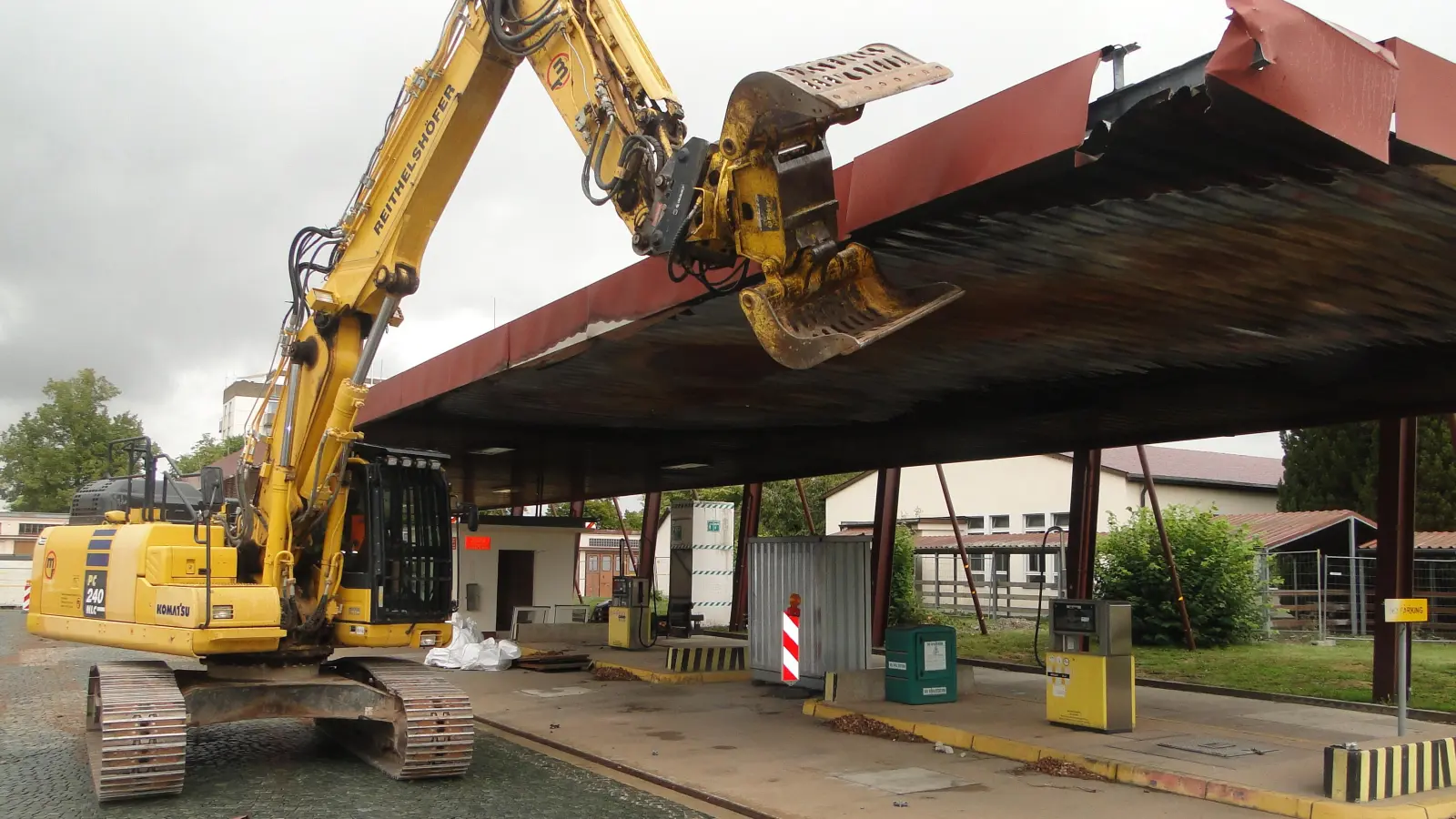 Der Bagger der Abriss-Firma hat damit begonnen, das Dach der historischen Tankstelle herunterzureißen. Bis November soll die gesamte Anlage inklusive der unterirdischen Tanks verschwunden sein. (Foto: Winfried Vennemann)