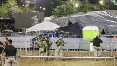 Sicherheitskräfte stehen um die Bühne, die zusammengebrochen ist. (Foto: Alberto Lopez/AP/dpa)