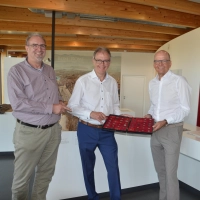 Einblicke in den Münzkoffer gewährte Museumsleiter Dr. Matthias Pausch (links) bei der Spendenübergabe der Sparkassenstiftung Ansbach durch Werner Frieß (rechts) an den Vorsitzenden des Fördervereins Römerpark Ruffenhofen, Bernd Großmann (Mitte). (Foto: Peter Tippl)