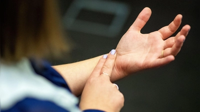 Zwei Finger, 30 Sekunden zählen, mal zwei nehmen – fertig ist der Minutenpuls. Wichtig: Nicht mit dem Daumen messen, der hat seinen eigenen Takt. (Foto: Bernd Diekjobst/dpa-tmn)