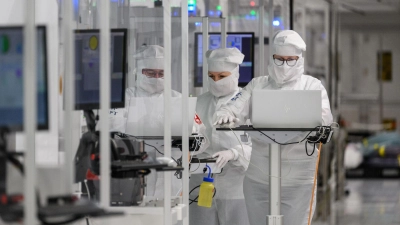 Infineon Mitarbeiter in eine Reinraum. Dem Konzern aus Neubiberg bei München ist ein Durchbruch bei Galliumnitrid gelungen.  (Foto: Robert Michael/dpa)