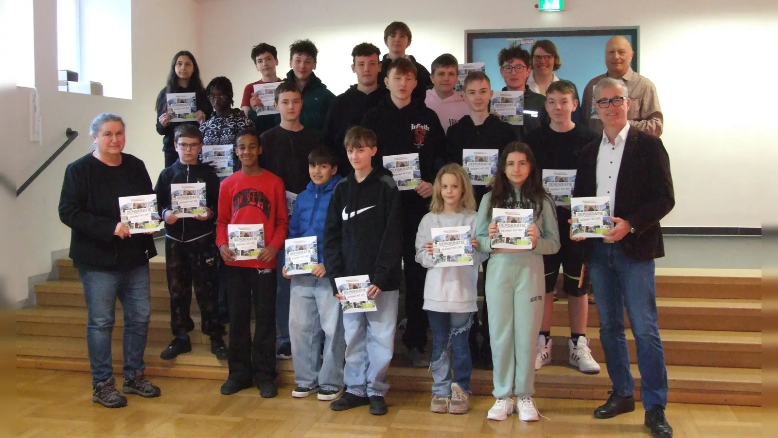 Bei der Übergabe der Demokratie-Broschüre: Mädchen und Jungen der beiden Feuchtwanger Grund- und Mittelschulen mit (links) Andrea Pöschl (Leiterin der Stadt-Schule), (rechts) Bürgermeister Patrick Ruh sowie (letzte Reihe, von rechts) Wilhelm Hintermeier (Konrektor der Mittelschule-Land) und Annette Schmutzer (Konrektorin der Stadt-Schule).  (Foto: Jasmin Kiendl)