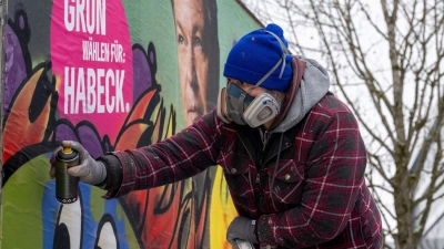 Im Auftrag der Grünen gestaltet der Künstler Bernd Imminger beschädigte Wahlplakate neu. (Foto: Stefan Puchner/dpa)