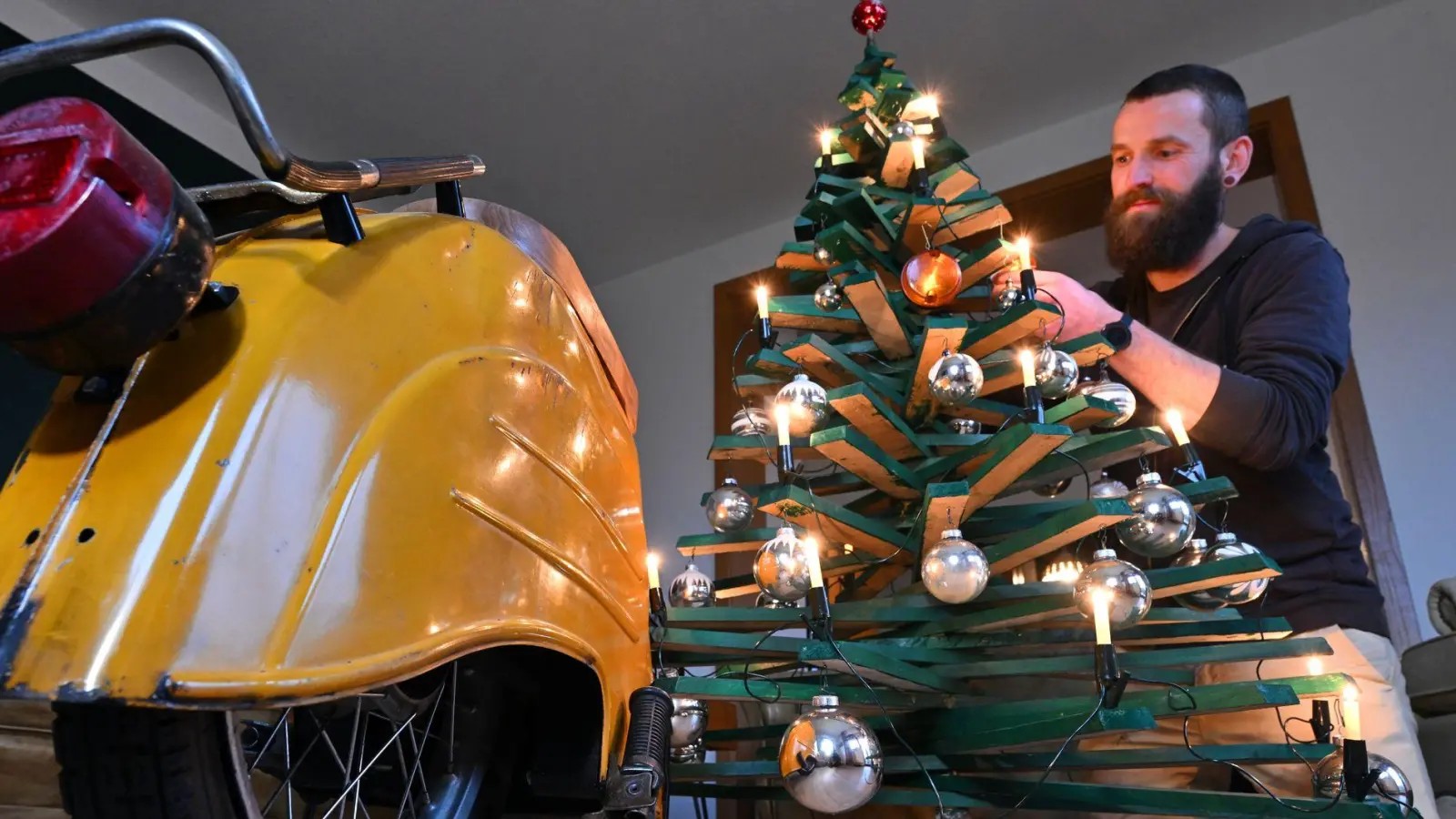 Jan Hofmann schmückt einen Weihnachtsbaum auch mit Weihnachtsbaumkugeln aus Simson-Blinkern. (Foto: Martin Schutt/dpa)