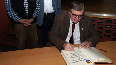 Helmut Zollhöfer (CSU, links) und sein Nachfolger Harry Scheuenstuhl (SPD, vorne) mit dem aktuellen Ortschef Uwe Emmert (CSU). Die beiden Altbürgermeister trugen sich ins Goldene Buch ein. (Foto: Heinz Wraneschitz)