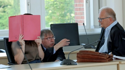 Die Angeklagte (l-r), wird von den Rechtsanwälten Andreas Ohm und Thomas Löcker verteidigt. (Foto: Bernd Wüstneck/dpa)