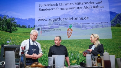Bundesminister Alois Rainer (links) und Christian Mittermeier beim gemeinsamen Kochen. Mit im Bild ist Moderatorin Carolin Kuhn.  (Foto: Ronny Hartmann / BMLEH)