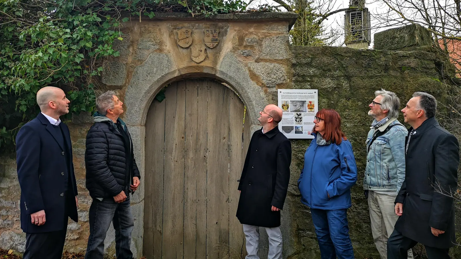 Aus drei Familienwappen besteht das Steinrelief, dessen Details auf Initiative des Vereins Alt-Rothenburg nun wieder besser erkennbar sind. Das Foto entstand bei einem Treffen von Vorstandsmitgliedern des Vereins mit Sponsorenvertretern und OB Dr. Markus Naser. (Foto: Jürgen Binder)