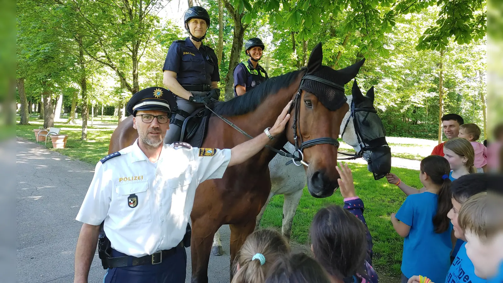 Rainer Mühlbauer, Susanne Klopf auf Leopold (braun) und Jasmin Kuttner auf Leander kommen im Kurpark mit Schülern der Delp-Schule ins Gespräch. (Foto: Katrin Merklein)