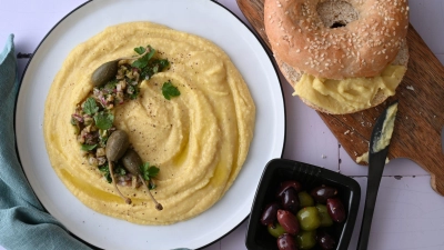 Der pürierte Dip ist aus gelben Linsen zubereitet. Sie sind etwas weniger süß und passen perfekt zu Kapern, Oliven und einem Sesambagel.   (Foto: Julia Uehren/loeffelgenuss.de/dpa-tmn)