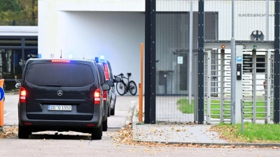 Mit eingeschaltetem Blaulicht fahren mehrere Wagen auf den Hof an der Außenstelle des Bundesgerichtshofs.  (Foto: Uli Deck/dpa)