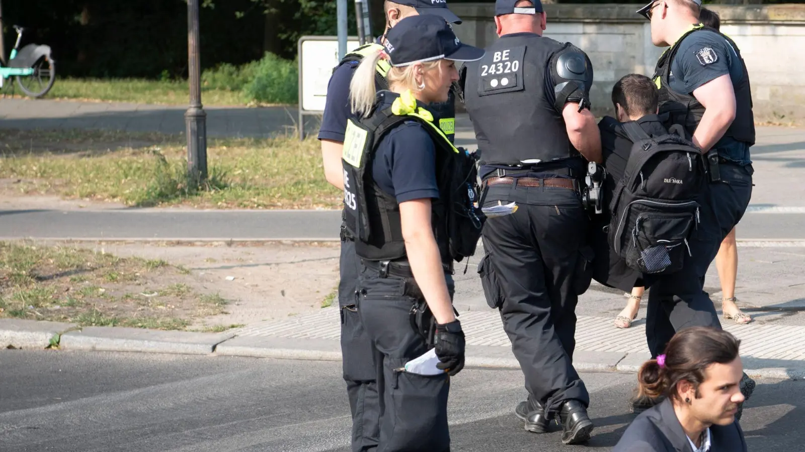 Die Polizei trägt einen Aktivisten der Gruppe Letzte Generation weg, der mit anderen die Fahrbahnen rund um die Siegessäule in Berlin blockiert hat. (Foto: Paul Zinken/dpa)