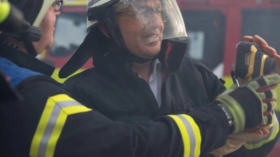 Bundesinnenminister Alexander Dobrindt (CSU) versucht sich als Feuerwehrmann. (Foto: Katharina Kausche/dpa pool/dpa)