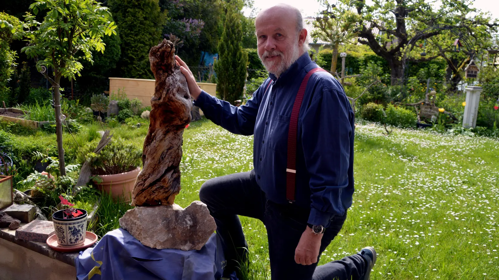 Der Uffenheimer Künstler Norbert Hettmer mit einer seiner Skulpturen im heimischen Garten. Das Schwemmholz hat etwas Flehendes, geschaffen von Mutter Natur. (Foto: Johannes Zimmermann)