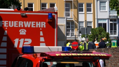 Rettungswagen, Polizisten und Polizeifahrzeuge stehen in der Nähe des Einsatzortes. (Foto: Sascha Ditscher/dpa)