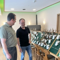 Fester Bestandteil einer Hegeschau und auch gesetzlich festgeschriebene Pflicht ist traditionell die Präsentation der Gehörne. Das Foto zeigt (von links) Gernot Fohrer, den zweiten Vorsitzenden der Jägervereinigung, mit Maximilian Seybold, dem Leiter der Unteren Jagdbehörde, vor den Tafeln. (Foto: Lukas Schneider)