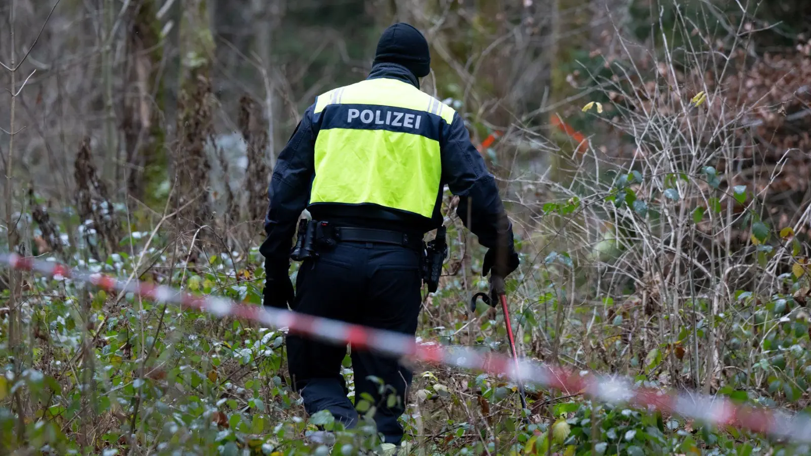 Ein Polizist nimmt an der Durchsuchung von einem Waldstück im Forstenrieder Park teil.  (Foto: Sven Hoppe/dpa)