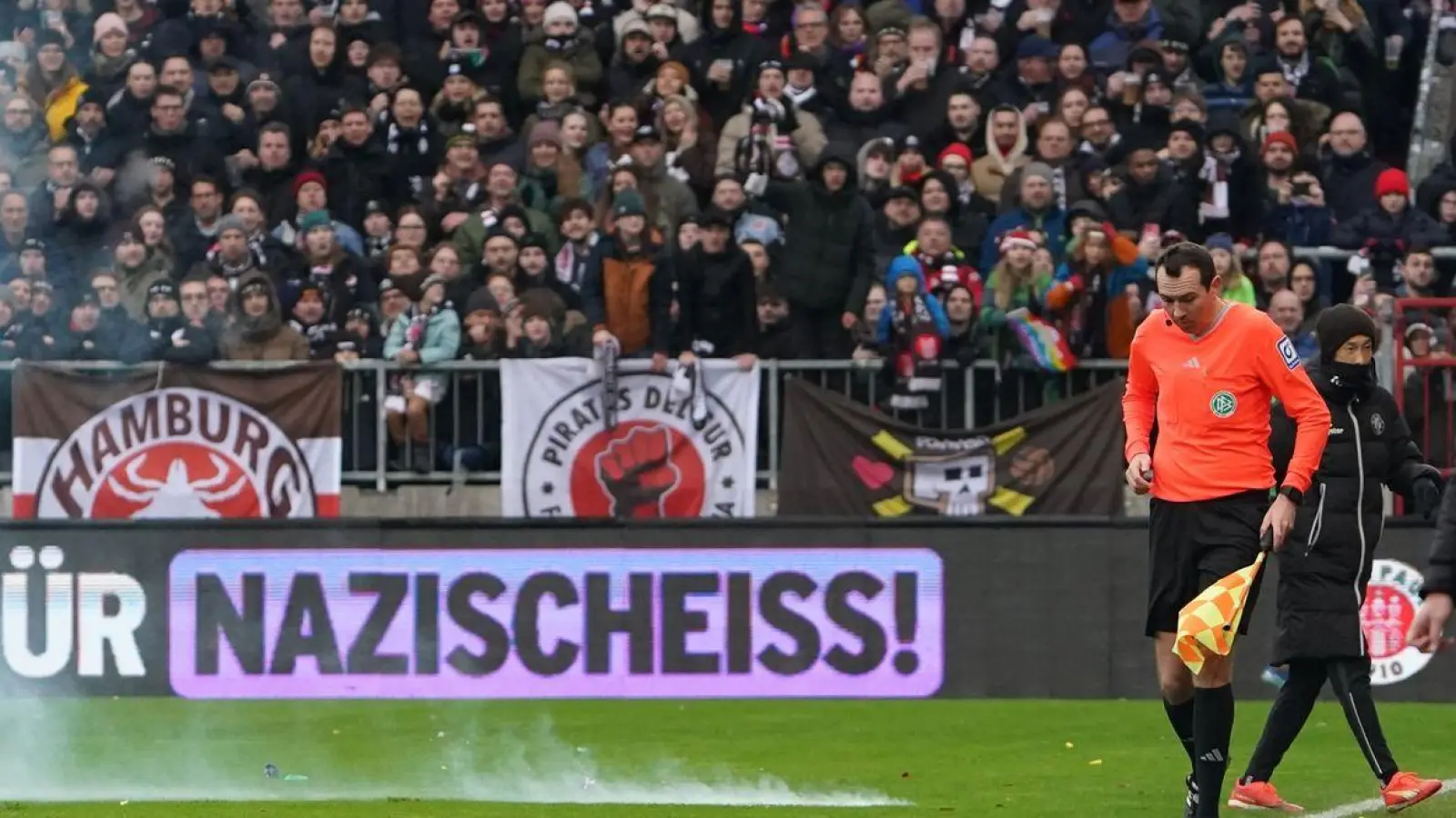 Ein Böller explodiert auf dem Spielfeld. (Foto: Marcus Brandt/dpa)