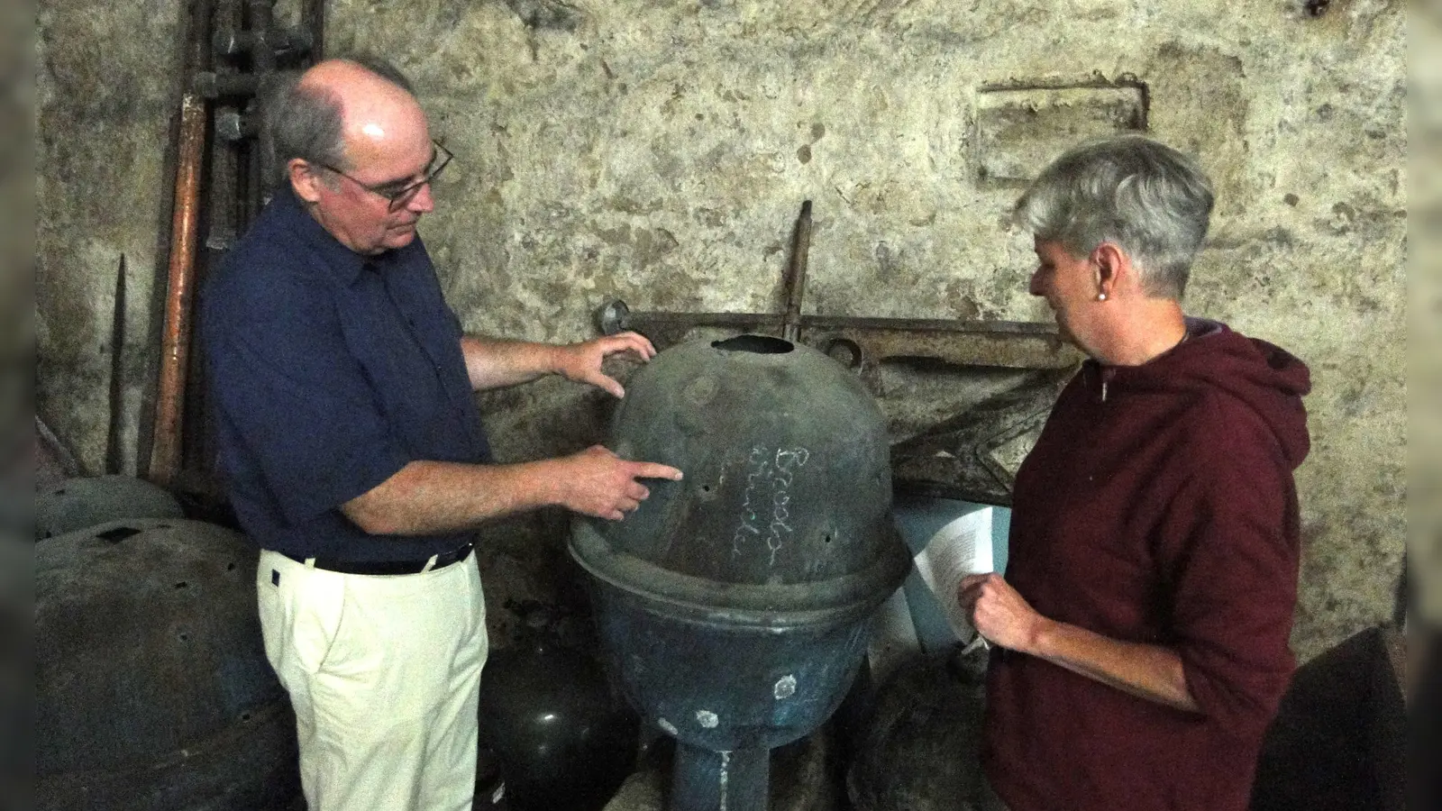 Susanne Frieß und Stadtführer Alexander Biernoth betrachten die Turmkugel, die einst die Brodswindener Kirche zierte. (Foto: Winfried Vennemann)