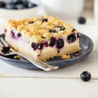 Streusel und Blaubeeren machen den Käsekuchen knusprig und fruchtig.  (Foto: Sonja Bauer/dpa-tmn)