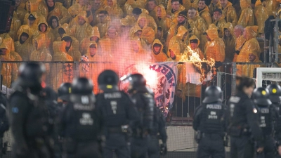 Beim Zweitliga-Spiel zwischen Dynamo Dresden und Hertha BSC kam es zu Ausschreitungen. Die Polizei drängte die Fans zurück in den Block, wo eine Hertha-Fahne verbrannt wird. (Foto: Sebastian Kahnert/dpa)